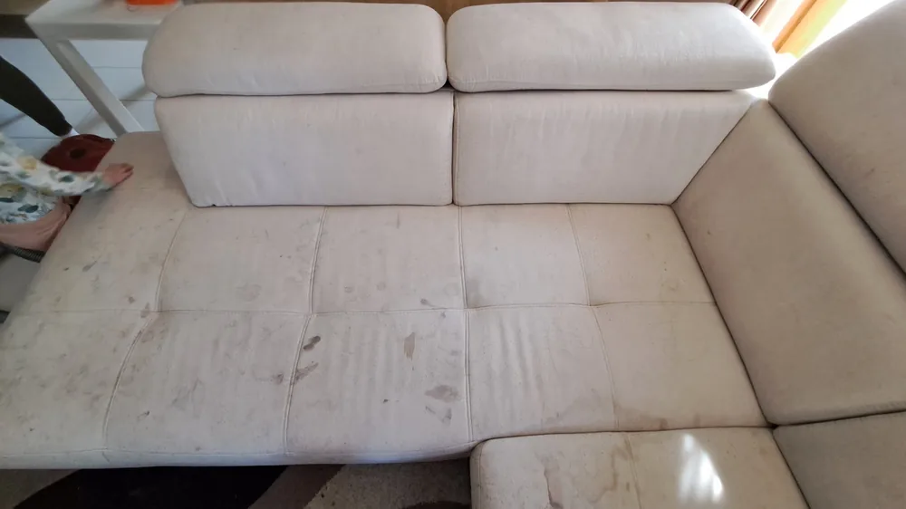 Helles Sofa mit dunklen Flecken auf der Sitzfläche