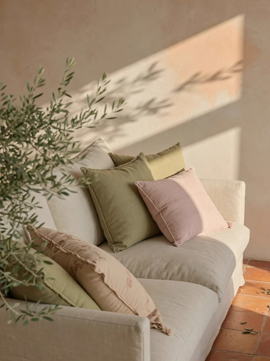 Leinensofa in einer Finca auf Mallorca, mit Olivenzweig und pastelligen Kissen