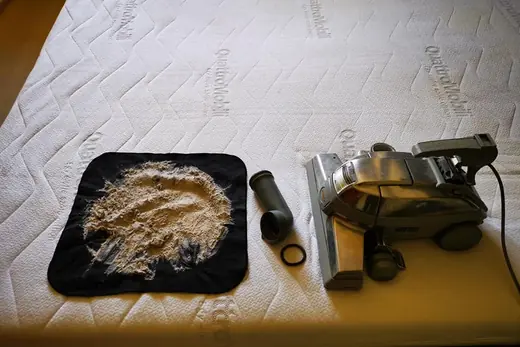 Ausgesaugter Matratzenstaub auf schwarzem Tuch neben dem Saugkopf, Aufnahme 13 von 25