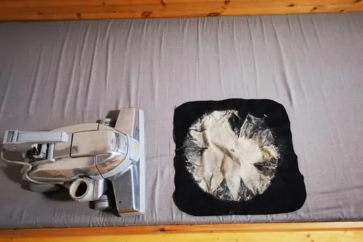 Ausgesaugter Matratzenstaub auf schwarzem Tuch neben dem Saugkopf, Aufnahme 15 von 25