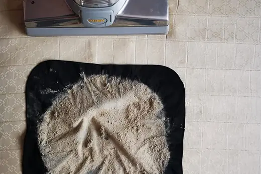 Ausgesaugter Matratzenstaub auf schwarzem Tuch neben dem Saugkopf, Aufnahme 24 von 25