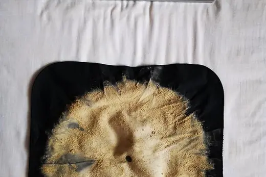 Ausgesaugter Matratzenstaub auf schwarzem Tuch neben dem Saugkopf, Aufnahme 25 von 25