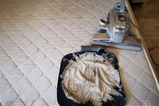 Ausgesaugter Matratzenstaub auf schwarzem Tuch neben dem Saugkopf, Aufnahme 3 von 25